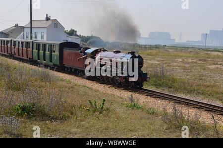 Narrow gauge steam locomotive pulling a coach train. A Narrow gauge steam locomotive pulling a train on the Romney, Hythe and Dymchurch railway Stock Photo