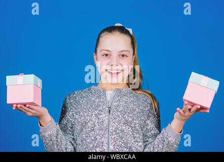 Special happens every day. Girl with gift boxes blue background. Black friday. Shopping day. Cute child carry gift boxes. Surprise gift box. Birthday wish list. World of happiness. Pick bonus. Stock Photo