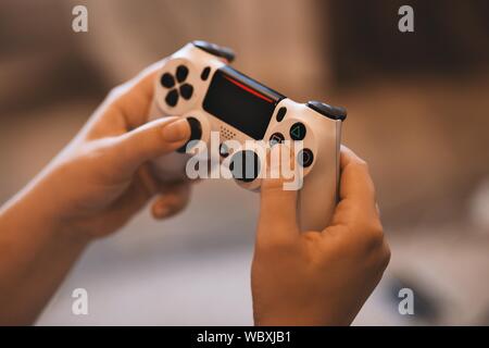 Selective closeup shot of a person holding wireless white gamepad Stock Photo