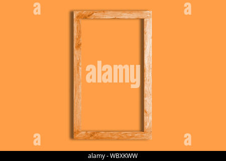 Orange background and mock up with empty wooden frame in a plain color table. Empty copy space for Editor's text. Stock Photo
