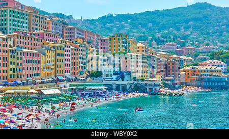 Camogli, Genoa, Italy - July 3, 2019:  Beach with resting people and waterfront colorful buildings in Camogli on sunny summer day, Liguria Stock Photo