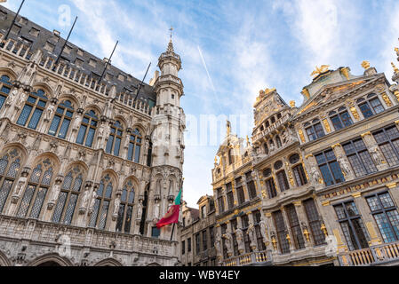 Architecture in Grand Place Brussels Belgium with an airplane in the background and a flag waving on a beautiful winter day Stock Photo