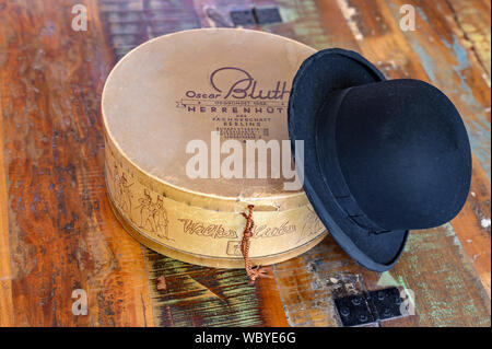 Berlin, Germany - August 25, 2019: A historic hatbox from Berlin in the 19th century with a bowler on an old wooden table. Stock Photo