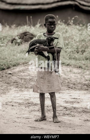 BOR, SOUTH SUDAN-NOVEMBER 2, 2013: An unidentified girl holds her goat in the town of Bor, South Sudan Stock Photo