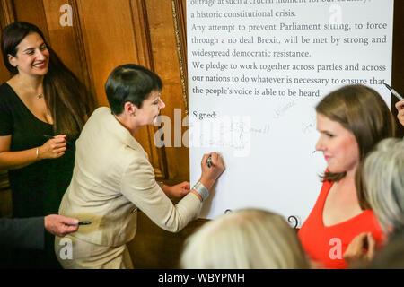 London, UK. 27th Aug, 2019. Caroline Lucas signs the declaration. Cross-party MPs and opposition party leaders assemble in the historic location of Church House in London to sign their 'Church House Declaration', with the intend to stop Parliament from being shut down by the government. Attendees include Lib Dem leader Jo Swinson, Labour Shadow Cabinet members John McDonnell and Sir Kier Starmer, the Green Party's Caroline Lucas, SNP's Ian Blackford and many others. Up to around 160 MPs are thought to have signed the declaration in total. Credit: Imageplotter/Alamy Live News Stock Photo
