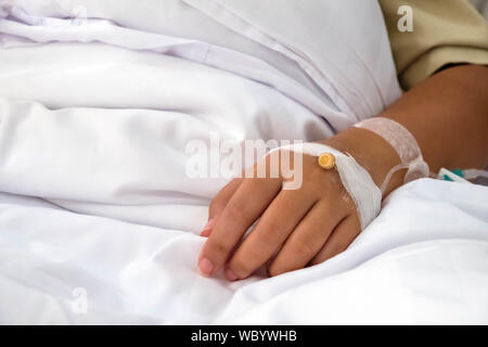 Patient in hospital in bed with intravenous medicine close up Stock Photo