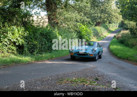 1970 Jaguar E Type going to a classic car show in the Oxfordshire countryside. Broughton, Banbury, England Stock Photo