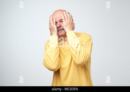 Desperate, stressed mature european man holding head, shocked by the quantity of problems. Stock Photo
