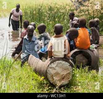 BOR, SOUTH SUDAN-NOVEMBER 2, 2013: Unidentified children play in dugout canoes south of Bor, South Sudan Stock Photo