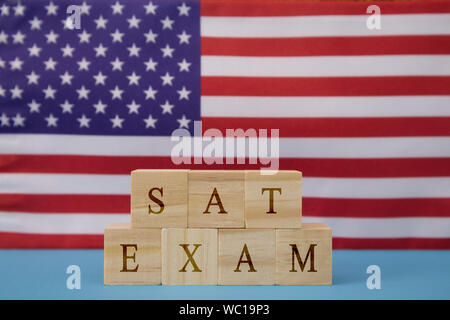 SAT Exam in Wooden block letters on US flag. Stock Photo