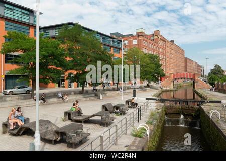 People enjoy the sunshine by the Rochdale Canal in Ancoats, Manchester, UK. Stock Photo