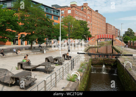 People enjoy the sunshine by the Rochdale Canal in Ancoats, Manchester, UK. Stock Photo