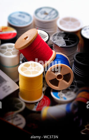 Group of spools of sewing thread in vaious stages of use and color. Stock Photo