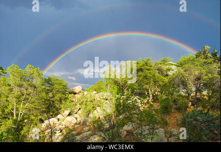 A Double rainbow shines brightly over the high desert landscape. Stock Photo