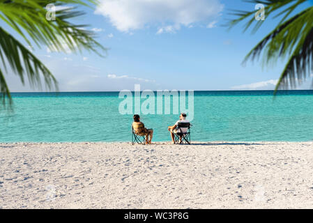 Salda lake like Maldives with white sand and turquoise colored water. One Couple sitting on portable chairs near the waters edge. Burdur / Turkey. Mou Stock Photo