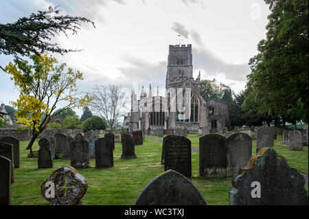 St Peter and St Pauls Church and its graveyard with tombs in Northleach town, Gloucestershire, Cotswolds, England - United Kingdom Stock Photo
