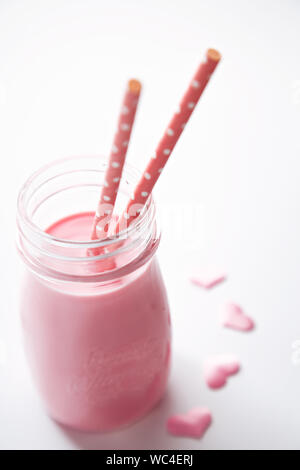 Close-up Of Raspberry Smoothie In Jar With Pink Straws Against White Background