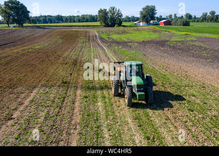 Three Oaks, Michigan - Dairy farmer Howard Payne spreads manure on a field as fertilizer. Stock Photo