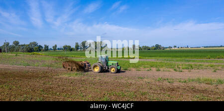 Three Oaks, Michigan - Dairy farmer Howard Payne spreads manure on a field as fertilizer. Stock Photo