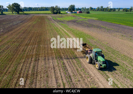 Three Oaks, Michigan - Dairy farmer Howard Payne spreads manure on a field as fertilizer. Stock Photo