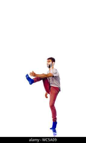 An urban guy is doing stretching on leg in the studio Stock Photo