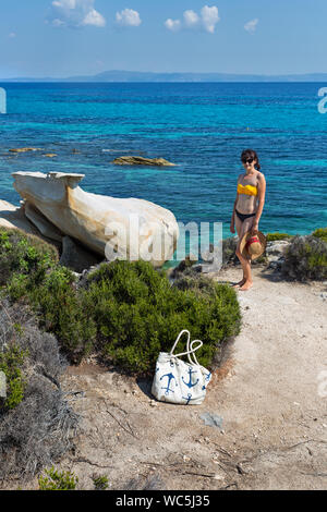 Beautiful young woman on exotic Platanitsi beach in Sarti, Sithonia, Greece with crystal clear water and spectacular shapes of rocks Stock Photo