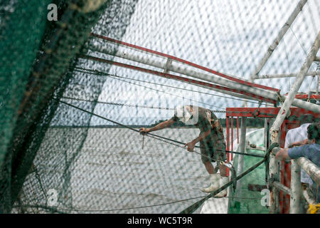 Commercial fishermen working on shrimping boat in South Carolina, view through the net Stock Photo