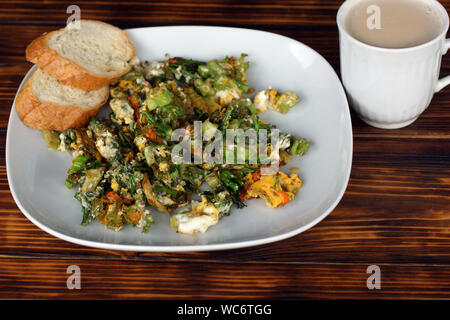 Eggs with vegetables and coffee with milk. Fine breakfast made from organic products. Healthy eating. Stock Photo