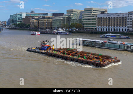 A large Multi-cat type workboat, MPV Shake Dog, delivers construction materials in the Pool of London, River Thames by Hays Galleria and London Bridge