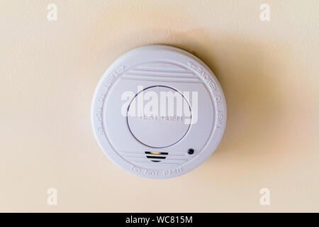White smoke detector on a ceiling close up Stock Photo