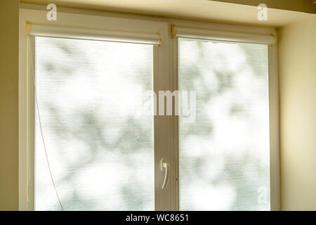light color fabric roller blinds on window in kitchen Stock Photo