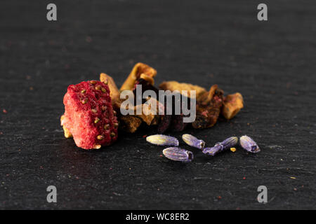 Lot of pieces of lavender strawberry ice tea on grey stone Stock Photo