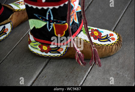 A Native American man wearing traditional Ojibwe beaded moccasins participates in a Native clothing contest at Santa Fe Indian Market in Santa Fe, NM. Stock Photo