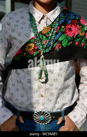 A young Navajo boy wearing traditional turquoise and silver Native jewelry enjoys visiting the Santa Fe Indian Market in Santa Fe, Mexico Stock Photo