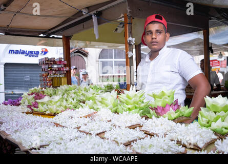 KANDY/ SRI LANKA, AUGUST 04-2019: The unspecific man who sell the lotus for pray of the Buddha Temple of the Sacred Tooth Relic at Kandy,Sri Lanka -UN Stock Photo