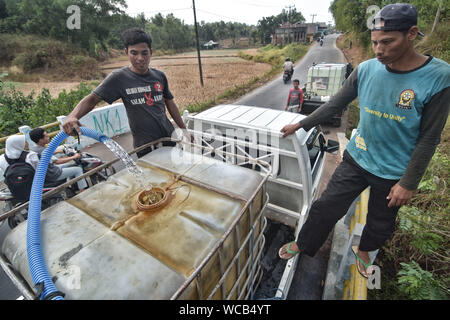 Bekasi, Indonesia. 27th Aug, 2019. Residents collect water from the waterways in Cibarusah.The Meteorology, Climatology and Geophysics Agency has warned that the dry season may be drier and more intense than last year due to the El Niño phenomenon. The agency classified that West Java, Central Java, most parts of East Java, Yogyakarta, Bali and Nusa Tenggara as the area's most vulnerable to extreme drought, or more than 60 days without rain. Credit: SOPA Images Limited/Alamy Live News Stock Photo