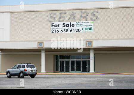 A faded outline of a logo sign outside of a closed and abandoned Sears retail store location in Mentor, Ohio on August 11, 2019. Stock Photo
