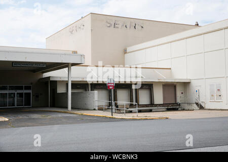 A faded outline of a logo sign outside of a closed and abandoned Sears retail store location in Mentor, Ohio on August 11, 2019. Stock Photo