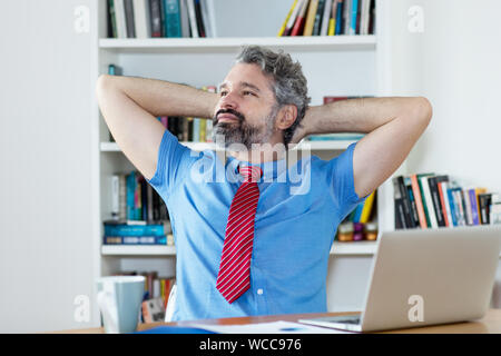 Relaxing mature businessman at office Stock Photo