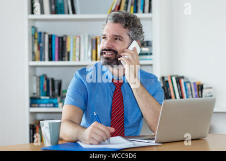 Mature financial advisor with beard talking with client at office of company Stock Photo
