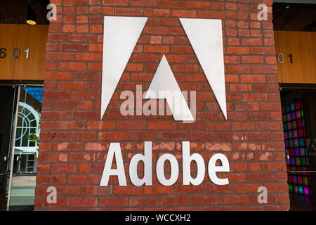 Adobe logo on the brick office facade of computer software company focused upon the creation of multimedia and creativity software products Stock Photo