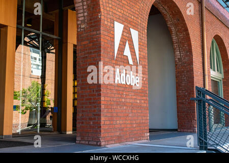 Adobe logo on the brick office facade of computer software company focused upon the creation of multimedia and creativity software products Stock Photo