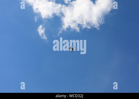Flight of the drone against the blue sky on a sunny day. quadcopter flying through the sky. New aerial photo and video technology Stock Photo