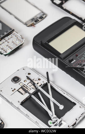 disassembled mobile phone and tools on white background Stock Photo