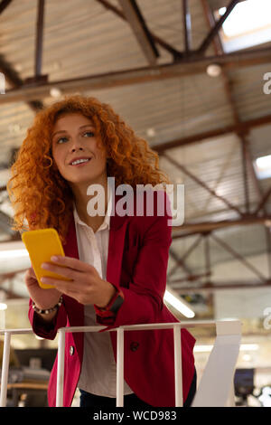Curly woman standing and enjoying little break from work Stock Photo