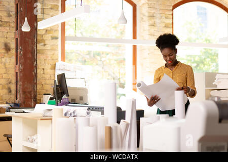 Worker of publishing agency checking the quality of paper Stock Photo