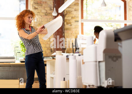 Worker of publishing office checking quality of paper Stock Photo