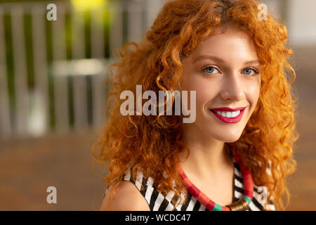 Beautiful red-haired woman with pink lips smiling broadly Stock Photo