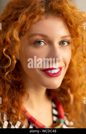 Close up of blue-eyed curly woman feeling motivated for work Stock Photo