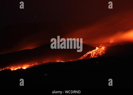 Mount Etna, Europe's biggest active volcano, erupts a new fracture, with the lava flow going towards the Torre del Filosofo (Philosopher’s Tower) in Nicolosi, a comune in Catania, Sicily. Featuring: atmosphere Where: Nicolosi, Catania, Italy When: 27 Jul 2019 Credit: IPA/WENN.com  **Only available for publication in UK, USA, Germany, Austria, Switzerland** Stock Photo